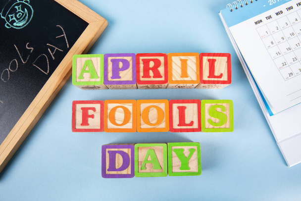 An overhead shot of wooden blocks spelling out "April Fools Day" on blue background - Foto, Bild