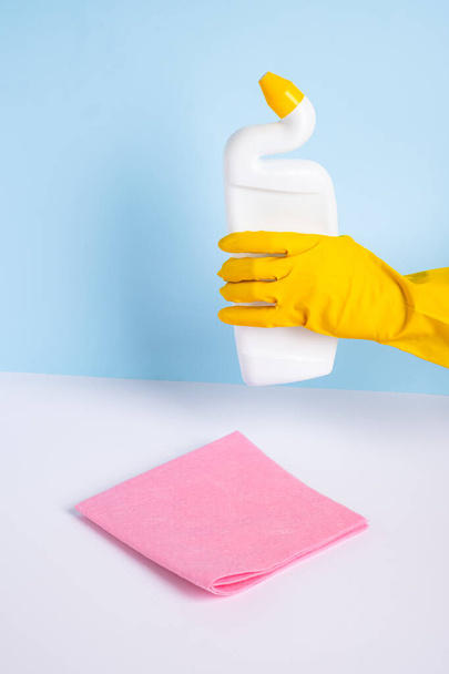 Woman hand in yellow rubber protective glove holding means for disinfection of a toilet bowl. Cleanliness and hygiene in the house. High quality photo - Zdjęcie, obraz