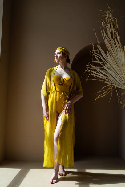 молода жінка в жовтій сукні позує в студії
 - Фото, зображення