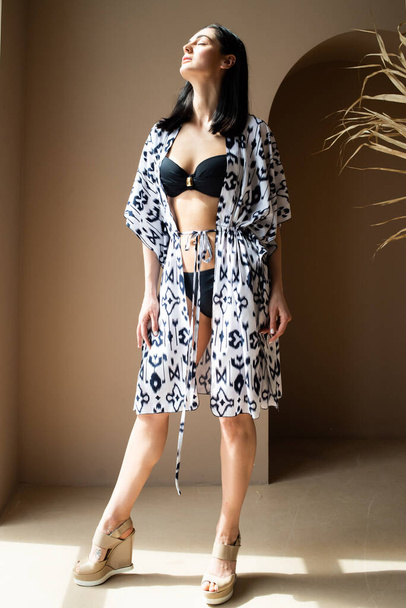 beautiful young woman in a stylish dress posing in studio - Foto, Imagen