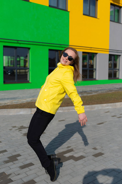 A redhead woman in sunglasses dancing in the street - Zdjęcie, obraz