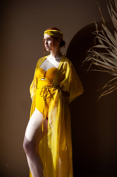belle jeune femme en robe jaune posant en studio - Photo, image