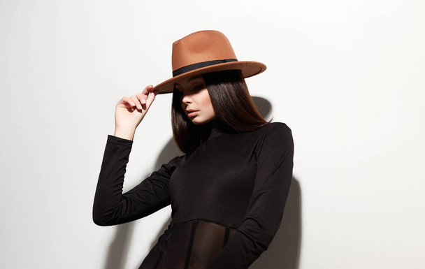 Красивая молодая женщина в шляпе. модный портрет брюнетки - Фото, изображение