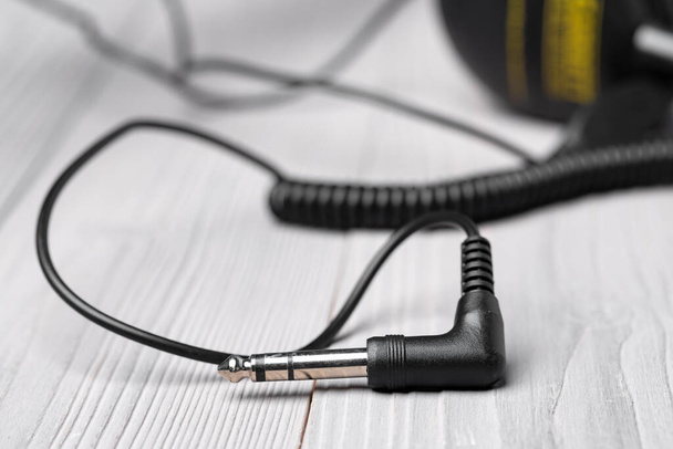 Black headphones with wire on wooden background - Foto, imagen