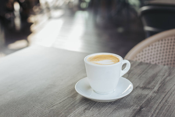 Kırsal ahşap masa üzerinde latte sanatıyla bir fincan kahve. Metin için yer. - Fotoğraf, Görsel