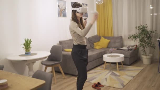 Młoda kobieta w słuchawkach VR podczas gry wideo dotykając czegoś niewidzialnego - Materiał filmowy, wideo