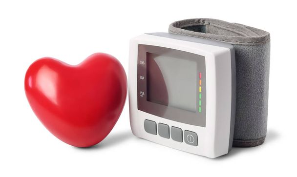 Digitális vérnyomás monitor (tonométer) és vörös szív közelében, elszigetelt fehér alapon. - Fotó, kép