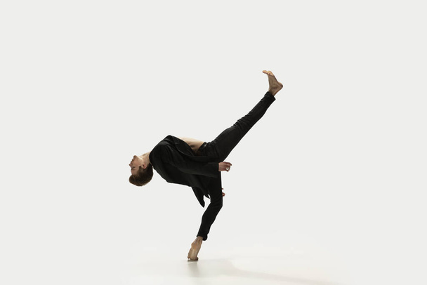 Man in casual style clothes jumping and dancing isolated on white background. Art, motion, action, flexibility, inspiration concept. Flexible caucasian ballet dancer. - 写真・画像