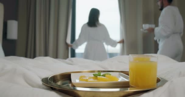 Man gives cup to woman focus on tray with juice and fruit - Footage, Video