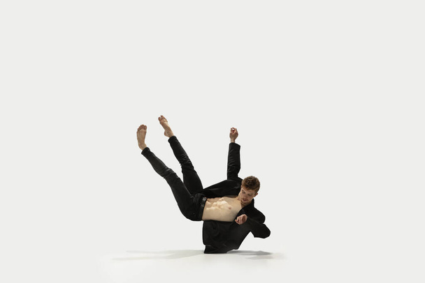 Man in casual style clothes jumping and dancing isolated on white background. Art, motion, action, flexibility, inspiration concept. Flexible caucasian ballet dancer. - Foto, imagen