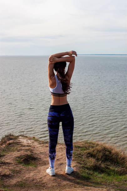 Young Asian Woman Practicing Yoga Pose On The Top Of Mountain Near Sea. - Foto, Imagen