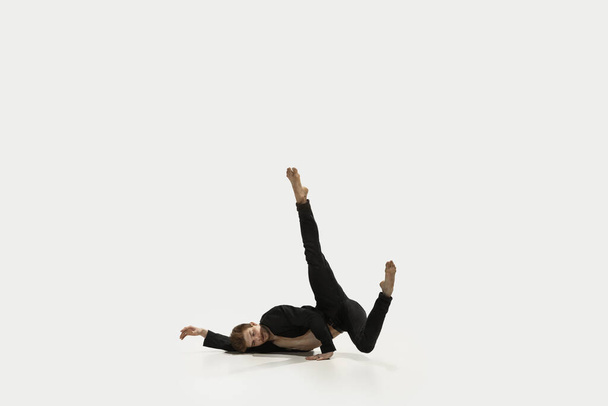 Homme en tenue décontractée sautant et dansant isolé sur fond blanc. Art, mouvement, action, flexibilité, concept d'inspiration. Danseuse de ballet caucasienne flexible. - Photo, image