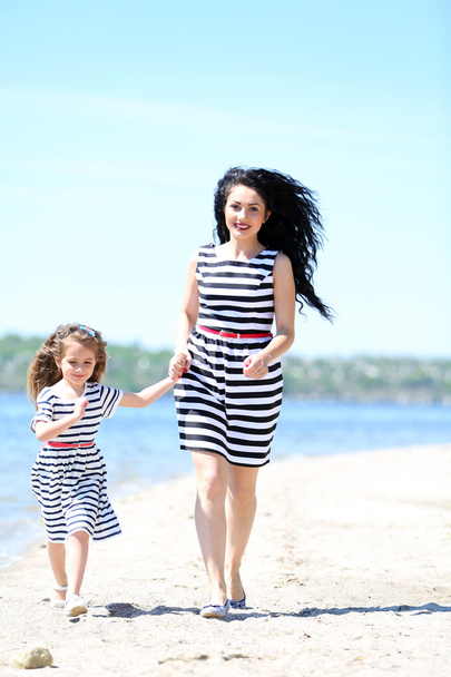Happy mom and daughter. Walk on the beach - Fotoğraf, Görsel