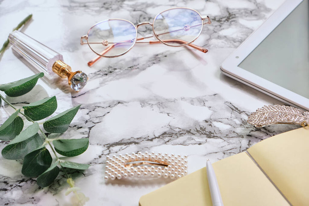 Female White marble office desk table with a lot of things, tablet, notepad, eyeglasses. copy space, flat lay. - Foto, Bild