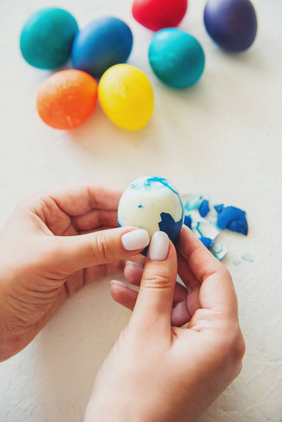 eggs. Easter. Easter eggs. colored eggs. Eggs on a white background. Eggshell. The girl cleans an egg. Girl's hands - Zdjęcie, obraz