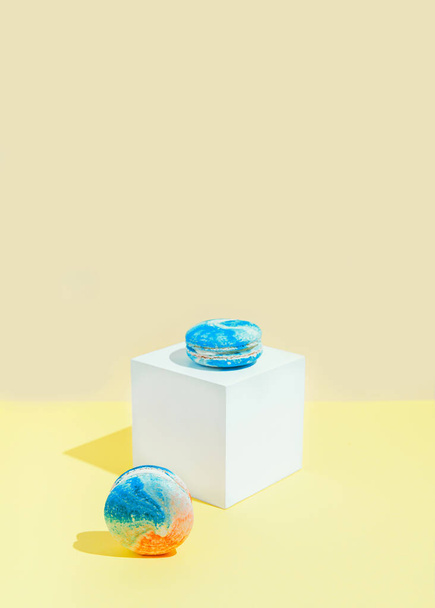 Macaroons on pastel background with white geometric figure. Minimal style composition. Dessert concept - Foto, afbeelding