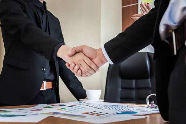 Επιχειρηματίες σφίγγουν το χέρι κατά τη διάρκεια μιας συνάντησης. - Φωτογραφία, εικόνα