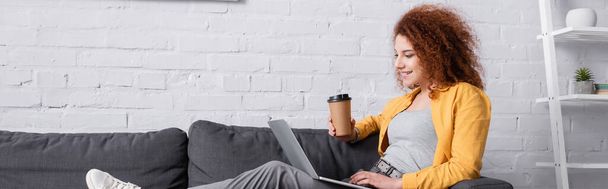 radostná žena sedí na gauči s kávou jít a notebook, banner - Fotografie, Obrázek