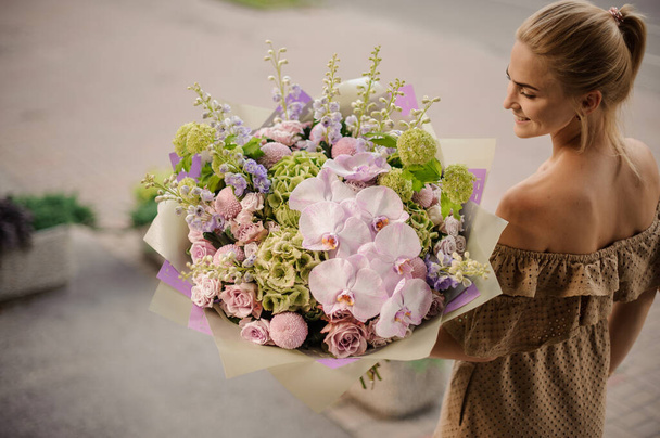 high angle view of blonde woman with large gorgeous bouquet in her hands - Photo, image