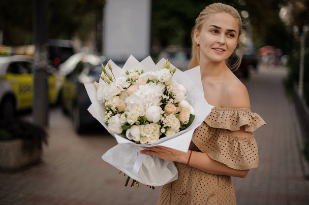 young attractive blonde woman holding gorgeous large bouquet of different white flowers - Photo, Image
