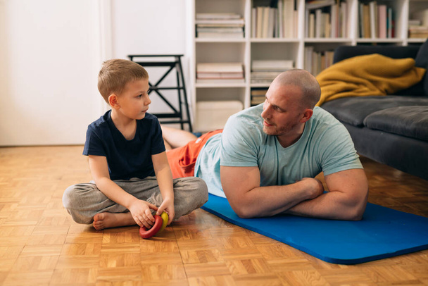 father and son exercise at home - Foto, afbeelding