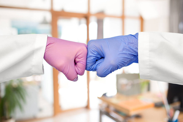 hands of doctors in gloves make fist bump gesture - 写真・画像