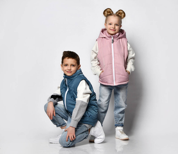Pre-teen boy and little girl in casual outwear vest studio shot - Foto, afbeelding