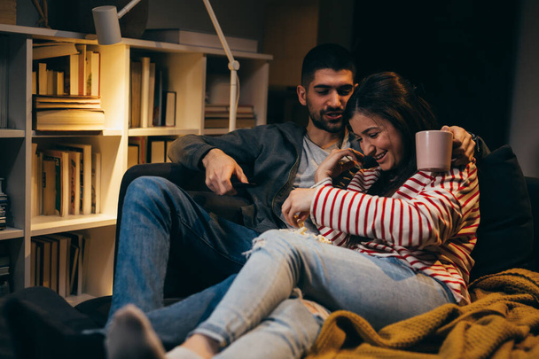 young couple watching television together at home - Valokuva, kuva