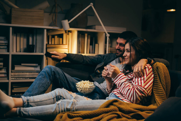 young couple watching television together at home - Φωτογραφία, εικόνα