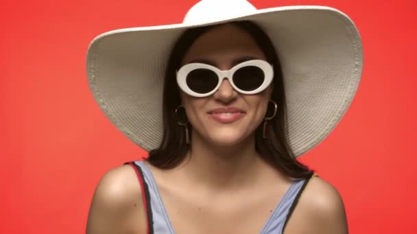 Excited woman in sunglasses gesturing isolated on red - Footage, Video