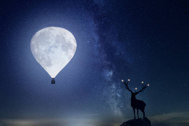 Magiczna gwiaździsta noc z jeleniem. Pełnia księżyca jest w kształcie balonu. - Zdjęcie, obraz