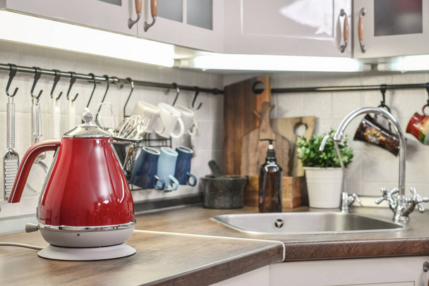 Red electric kettle in retro slile  in kitchen interior closeup - 写真・画像