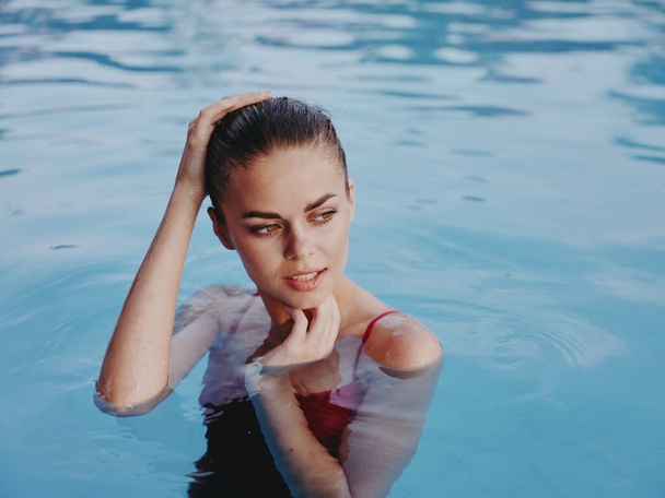 красива жінка в купальнику тримає руку на голові крупним планом
 - Фото, зображення