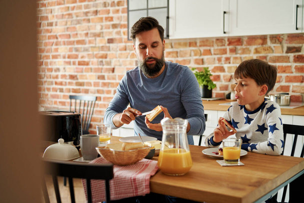 Отец и сын завтракают вместе утром - Фото, изображение