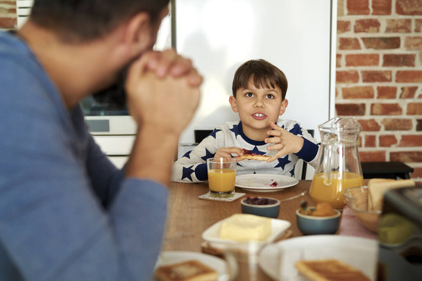 Vater und Sohn unterhalten sich beim Frühstück - Foto, Bild