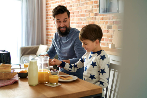 Heureux père et fils pendant le petit déjeuner le matin                                - Photo, image