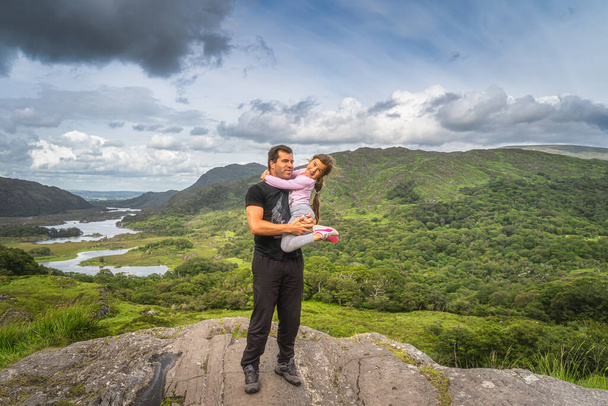 Baba kızını elinde tutuyor ve kayanın üzerinde duruyor, güzel bayanlar manzarası, ikonik İrlanda bakış açıları, Killarney, Kerry Rink, İrlanda - Fotoğraf, Görsel
