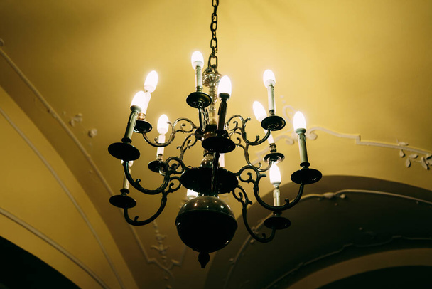 Lustre de metal preto em estilo barroco com teto e lâmpadas de vela. - Foto, Imagem
