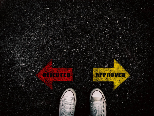 Rejected and approved red and yellow arrow on street and sneaker shoe background, business concept - Photo, Image
