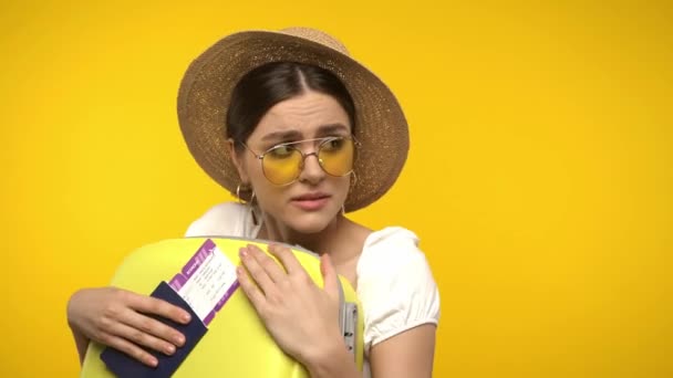 Τρομαγμένος ταξιδιώτης με βαλίτσα και διαβατήριο απομονωμένο στο κίτρινο - Πλάνα, βίντεο