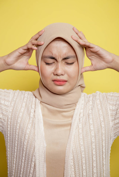 close up woman hijab with a dizzy expression thinking something holding the head - Foto, Imagen