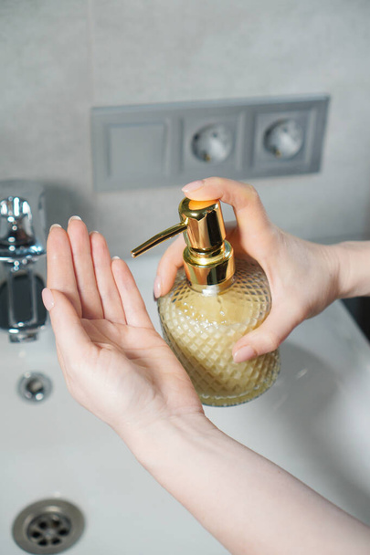 Hands hygiene. Washing hands with a liquid soap dispenser. Vertical photography. - Фото, изображение