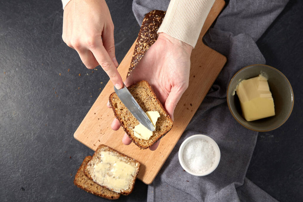 female baker spreading butter on homemade bread - Foto, immagini