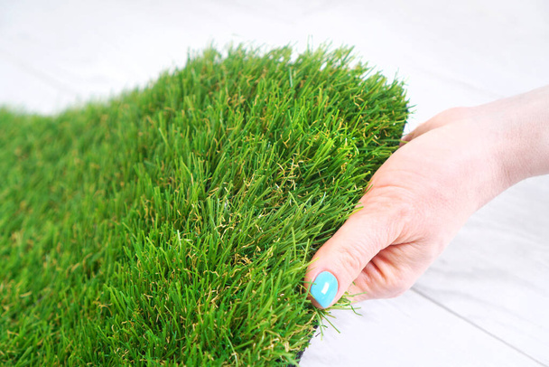 Female hand testing a green artificial grass - Photo, Image