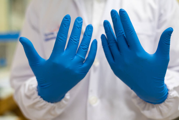 実験室での青い手袋のテストで手の科学者. - 写真・画像