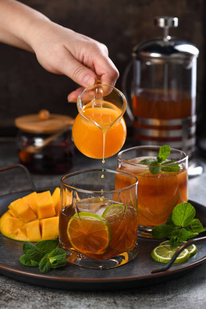 Παγωμένο τσάι μάνγκο με λάιμ και μέντα. Δροσιστικό βιολογικό αναψυκτικό - Φωτογραφία, εικόνα