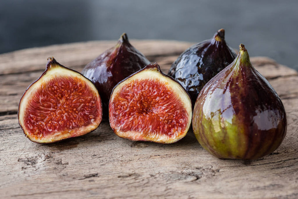 A few ripe figs on an old wooden background. Seasonal fruits. - Foto, afbeelding