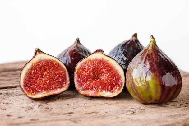 A few ripe figs on an old wooden background. Seasonal fruits. - Photo, Image