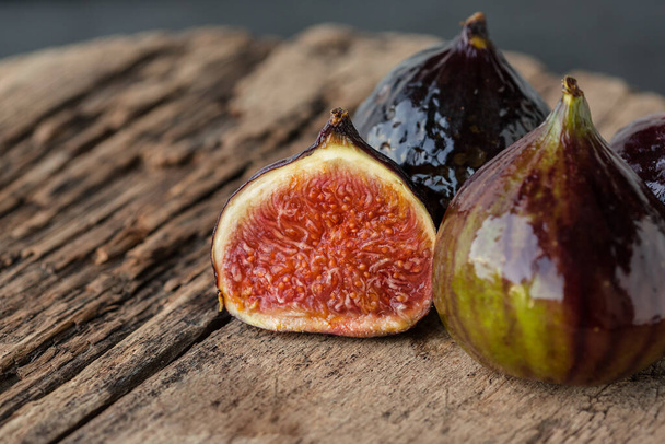 A few ripe figs on an old wooden background. Seasonal fruits. - Fotografie, Obrázek
