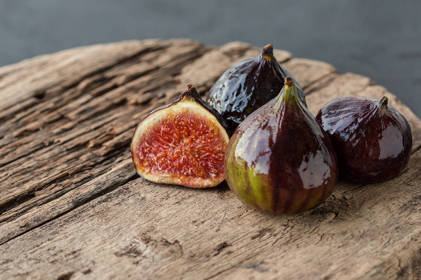 A few ripe figs on an old wooden background. Seasonal fruits. - Photo, Image